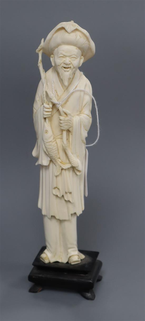 A carved ivory fisherman H.23cm including stand